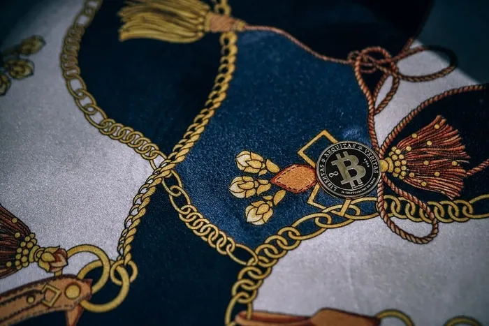 物理镀金比特币放置在带有金链图案的织物上。