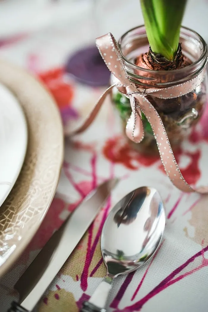 复活节餐桌上有可爱的粉色装饰、鲜花、柳絮和鸡蛋