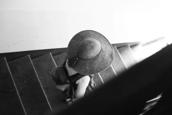 一个戴帽子的女孩走下楼梯
