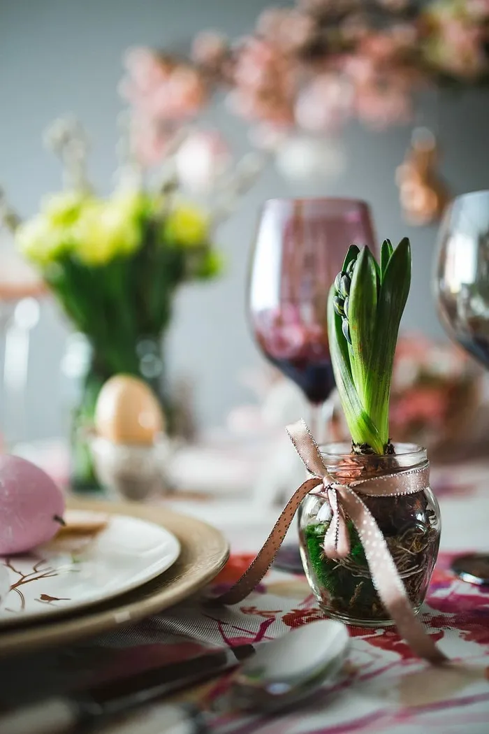 复活节餐桌上有可爱的粉色装饰、鲜花、柳絮和鸡蛋