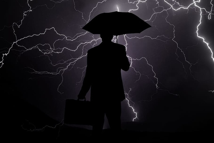 剪影男人手拿公文包雨伞商人危机雨