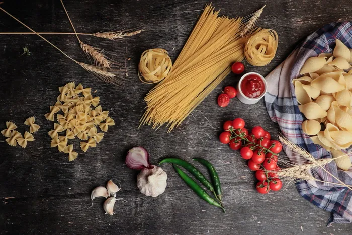 意大利面、西红柿、番茄酱、洋葱和大蒜的平面照片