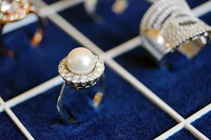 蓝色表面的白色珍珠戒指