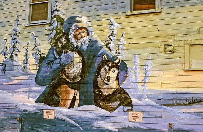 墙上挂着一位老人和两只雪橇狗的壁画