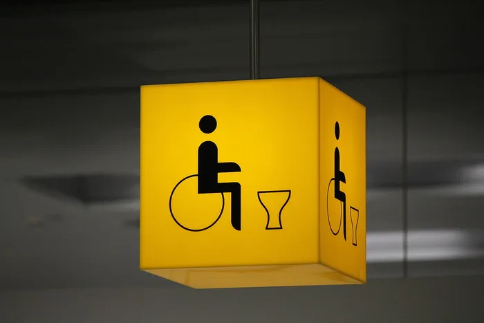 黄色悬挂标牌，残疾人厕所，残疾人，轮椅，轮椅使用者，厕所，厕所，注释