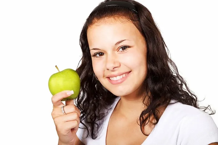 女人，白色，衬衫，手握，绿色，苹果，微笑，节食
