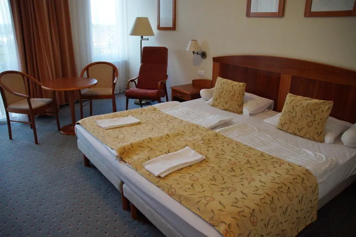 黄色，whote床罩，旁边，扶手椅，窗户，双人床，酒店，房间