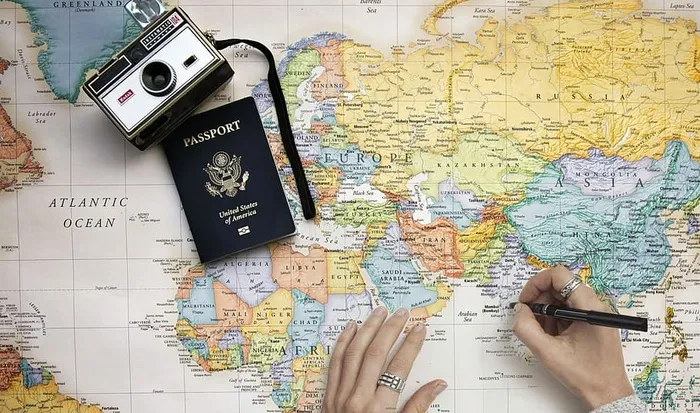 以世界旅游为主题的概念照片。带着世界男子、相机和护照计划旅行的人。