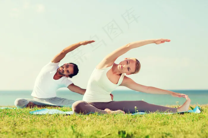 草地上练瑜伽的夫妻图片