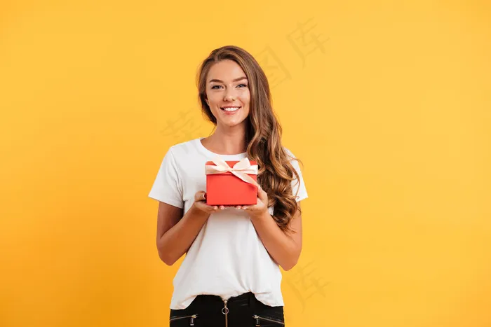 一个漂亮的微笑女孩拿着礼品盒的画像