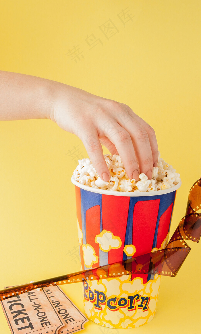手拿电影票和纸杯里的爆米花