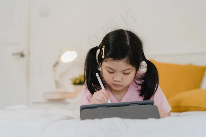 年轻的亚洲女孩在家画画。亚洲日本女人小孩睡前放松休息愉快快乐画漫画躺在床上，晚上在卧室里感受舒适和平静的概念。