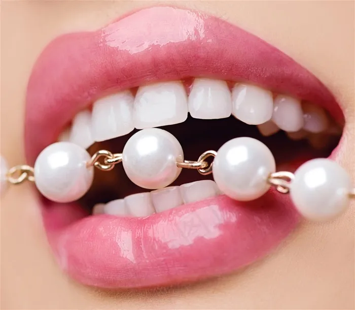 洁白的牙齿咬住的珍珠项链高清图片