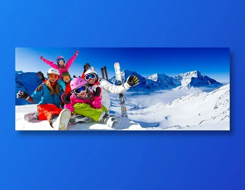 阳光照射的雪山和穿着滑雪装备的一家人高清图片