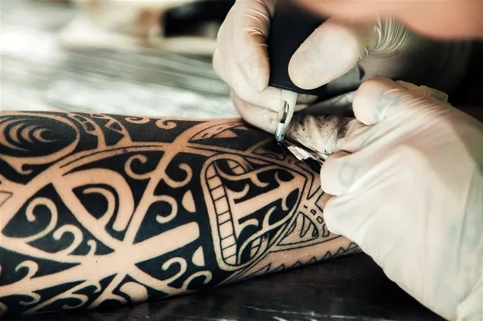 正在做手臂纹身的纹身师高清图片
