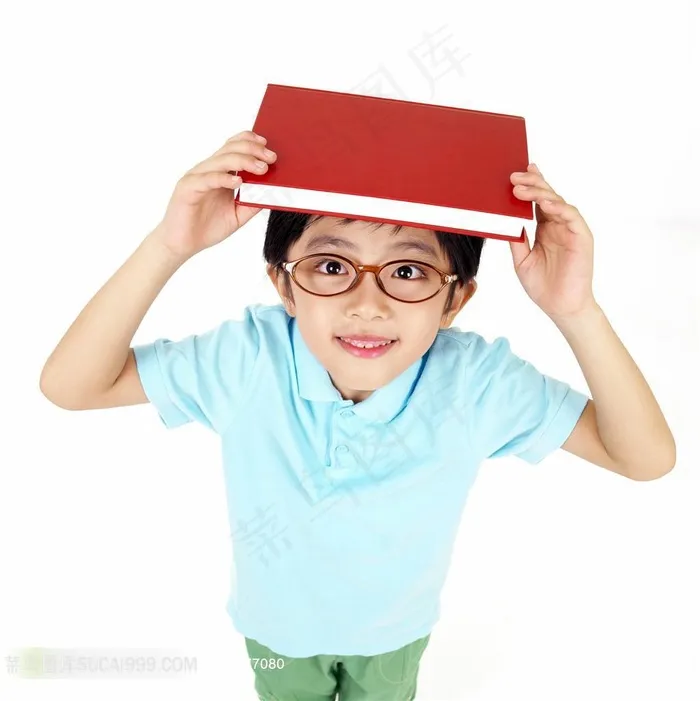 戴眼镜头顶书本的男孩素材