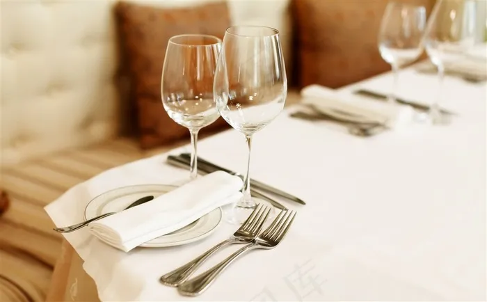 白色餐桌上摆放整齐的西式餐具高清图片