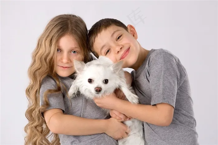 抱着白色小狗的男孩和女孩高清图片