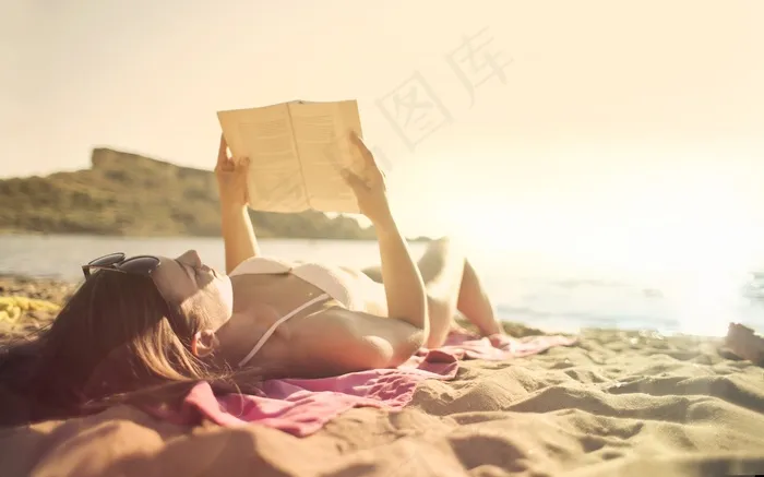 躺在沙滩上看书的美女图片