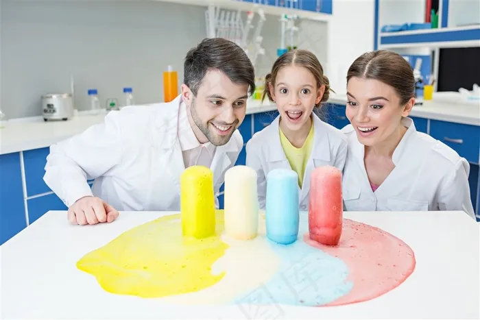 微笑的一家三口和桌子上的彩色化学液体高清图片