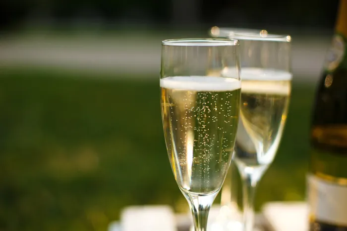 绿色模糊背景上的香槟眼镜，户外野餐周末