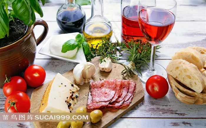 木板上的奶酪火腿西红柿橄榄油和酒摄影图片