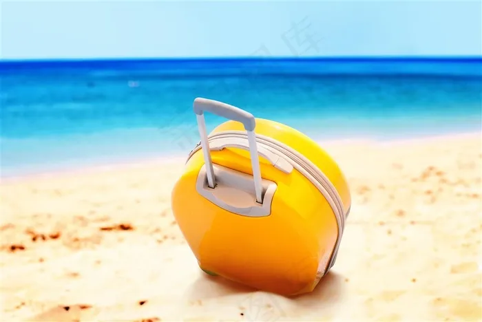 沙滩上的黄色拉杆箱和蓝色大海高清图片