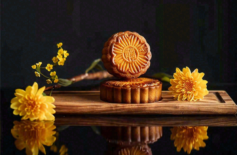 中国传统美食月饼中秋节菊花摆盘黑色背景摄影图