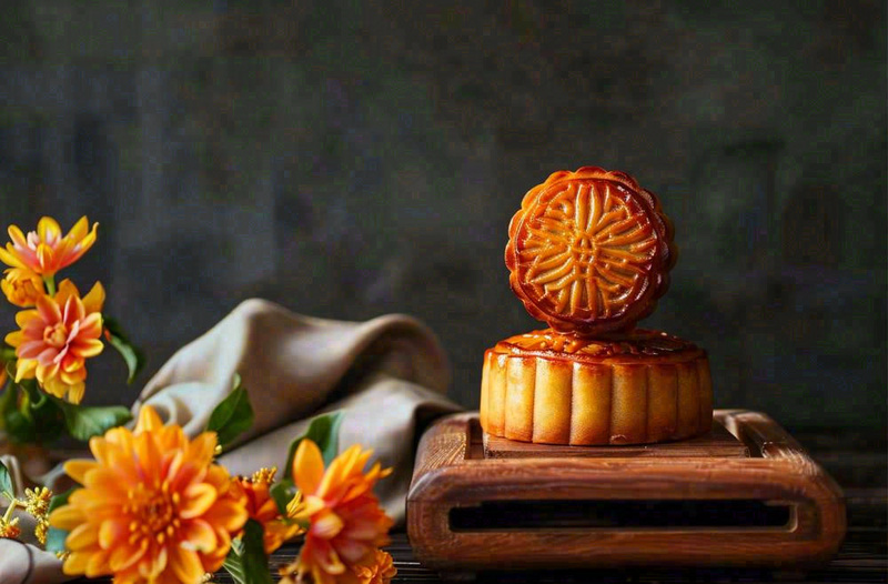 中国传统美食月饼中秋节菊花摆盘黑色背景摄影图