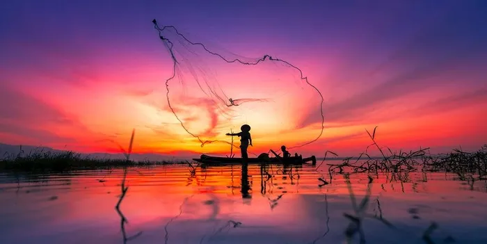 黄昏下的捕鱼场景图片