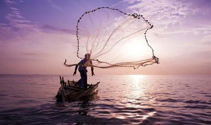 抛洒渔网捕鱼图片